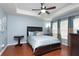 Main bedroom with hardwood floors, ceiling fan, and large windows at 17409 New Cross Cir, Lithia, FL 33547