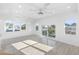 Bright and airy bedroom with hardwood floors, a ceiling fan, and multiple windows at 18077 3Rd St, Redington Shores, FL 33708