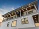 Three-story home with balconies and a rooftop deck at dusk at 18077 3Rd St, Redington Shores, FL 33708