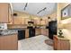 Well-equipped kitchen with light wood cabinets and black appliances at 1819 Ravenridge St, Wesley Chapel, FL 33543