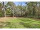 Large backyard with trampoline and lush greenery, providing ample space for recreation at 19387 Hidden Oaks Dr, Brooksville, FL 34604