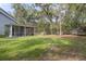 House backyard view with screened porch and large grassy area at 19387 Hidden Oaks Dr, Brooksville, FL 34604