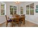 Bright breakfast nook with wood table and chairs, surrounded by windows at 19387 Hidden Oaks Dr, Brooksville, FL 34604