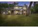 Two-story home with wrap-around porch, lit at night at 19387 Hidden Oaks Dr, Brooksville, FL 34604