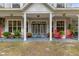 Two-story house with a front porch, gray siding, and red rocking chairs at 19387 Hidden Oaks Dr, Brooksville, FL 34604