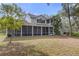 Two-story house showcasing a large backyard and screened porch at 19387 Hidden Oaks Dr, Brooksville, FL 34604