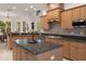 Kitchen with granite island, wood cabinets, and stainless steel appliances at 19387 Hidden Oaks Dr, Brooksville, FL 34604