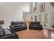 Relaxing living room with hardwood floors, leather furniture, and access to backyard at 19387 Hidden Oaks Dr, Brooksville, FL 34604