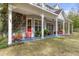 Front porch with rocking chairs and lush landscaping at 19387 Hidden Oaks Dr, Brooksville, FL 34604