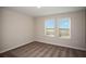 Bright bedroom with neutral walls and carpet, featuring two large windows with blinds at 2049 Stillview Pass, Zephyrhills, FL 33541