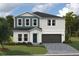 Two-story home with gray and blue siding, dark garage door, and landscaping at 2049 Stillview Pass, Zephyrhills, FL 33541