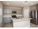 Modern kitchen with gray cabinets, quartz countertops, and stainless steel appliances at 2049 Stillview Pass, Zephyrhills, FL 33541