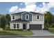 Two-story home with gray and blue siding, dark brown garage door, and landscaping at 2073 Stillview Pass, Zephyrhills, FL 33541