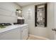Convenient laundry room with washer, dryer, and storage shelves at 2103 Stillview Pass, Zephyrhills, FL 33541