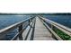 Dock stretching out on blue lake waters with clear sky and wooden rails at 2221 Swedish Dr # 11, Clearwater, FL 33763
