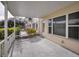 A covered patio features concrete flooring and white railing with views of community landscaping at 2221 Swedish Dr # 11, Clearwater, FL 33763