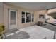 A covered patio features concrete flooring, a white door, and a screened window overlooking a garden at 2221 Swedish Dr # 11, Clearwater, FL 33763