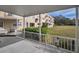 A covered patio features white railings overlooking the complex lawn and community landscaping at 2221 Swedish Dr # 11, Clearwater, FL 33763