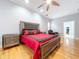 Main bedroom with king-size bed, hardwood floors, and ceiling fan at 2898 Grey Oaks Blvd, Tarpon Springs, FL 34688