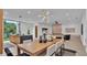 Open concept dining area with modern wood table and statement lighting at 3010 W Trilby Ave, Tampa, FL 33611