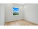 Small bedroom with light wood floors and one window at 3431 Palometa Dr, Hernando Beach, FL 34607