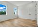 Simple bedroom with light wood floors and two windows at 3431 Palometa Dr, Hernando Beach, FL 34607
