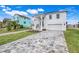 Two-story white house, gray pavers, and nicely landscaped lawn at 3431 Palometa Dr, Hernando Beach, FL 34607