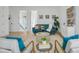 Open concept living area with a teal sofa and armchairs, hardwood floors, and a modern coffee table at 3431 Palometa Dr, Hernando Beach, FL 34607