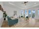 Spacious living room with hardwood floors, teal sofa, and access to a balcony with water views at 3431 Palometa Dr, Hernando Beach, FL 34607