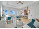 Bright living room with open floor plan, featuring stylish teal sofas and access to a balcony at 3431 Palometa Dr, Hernando Beach, FL 34607
