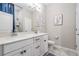 Double vanity bathroom with white cabinets and a large mirror at 34432 Wynthorne Pl, Wesley Chapel, FL 33545
