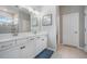 Double vanity bathroom with white cabinets and a large mirror at 34432 Wynthorne Pl, Wesley Chapel, FL 33545