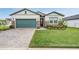 House exterior with green garage door and a well-maintained lawn at 34432 Wynthorne Pl, Wesley Chapel, FL 33545