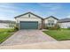Charming one-story home with green garage door and stone accents at 34432 Wynthorne Pl, Wesley Chapel, FL 33545