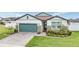 Two-story house with a teal garage door, stone accents, and a manicured lawn at 34432 Wynthorne Pl, Wesley Chapel, FL 33545