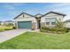 House exterior showcasing a teal garage door and stone accents at 34432 Wynthorne Pl, Wesley Chapel, FL 33545