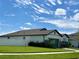 House exterior, green garage door and stone accents, grassy yard at 34432 Wynthorne Pl, Wesley Chapel, FL 33545