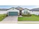 One-story home with green garage door and stone accents at 34432 Wynthorne Pl, Wesley Chapel, FL 33545
