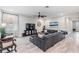 Living area with gray sectional sofa, large TV, and wood flooring at 34432 Wynthorne Pl, Wesley Chapel, FL 33545