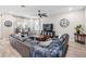 Spacious living room featuring a large sectional sofa and a wood coffee table at 34432 Wynthorne Pl, Wesley Chapel, FL 33545