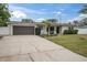 Ranch home with gray garage door and well-manicured lawn at 5084 42Nd S St, St Petersburg, FL 33711