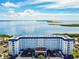 Aerial view of a waterfront condo building with beautiful water and landscape views at 7 Elgin Pl # 603, Dunedin, FL 34698