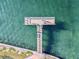 Aerial view of a T-shaped pier extending over calm water at 7 Elgin Pl # 603, Dunedin, FL 34698