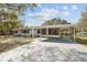 Gray house with carport and mature landscaping at 10308 Forest Hills Dr, Tampa, FL 33612