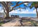 Scenic waterfront view with benches under a large tree at 1145 Boca Ciega Isle Dr, St Pete Beach, FL 33706