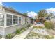House exterior showcasing a side view with a patio, landscaping, and a large window at 130 90Th Ave, Treasure Island, FL 33706
