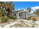 Gray cottage with a screened porch and small yard, surrounded by palm trees at 130 90Th Ave, Treasure Island, FL 33706