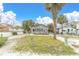 A small beach house with a sandy front yard and palm trees at 130 90Th Ave, Treasure Island, FL 33706