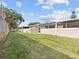 Large backyard with grassy area and a wooden fence at 1581 Amberlea S Dr, Dunedin, FL 34698