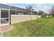Private backyard with grassy area and screened patio at 1581 Amberlea S Dr, Dunedin, FL 34698